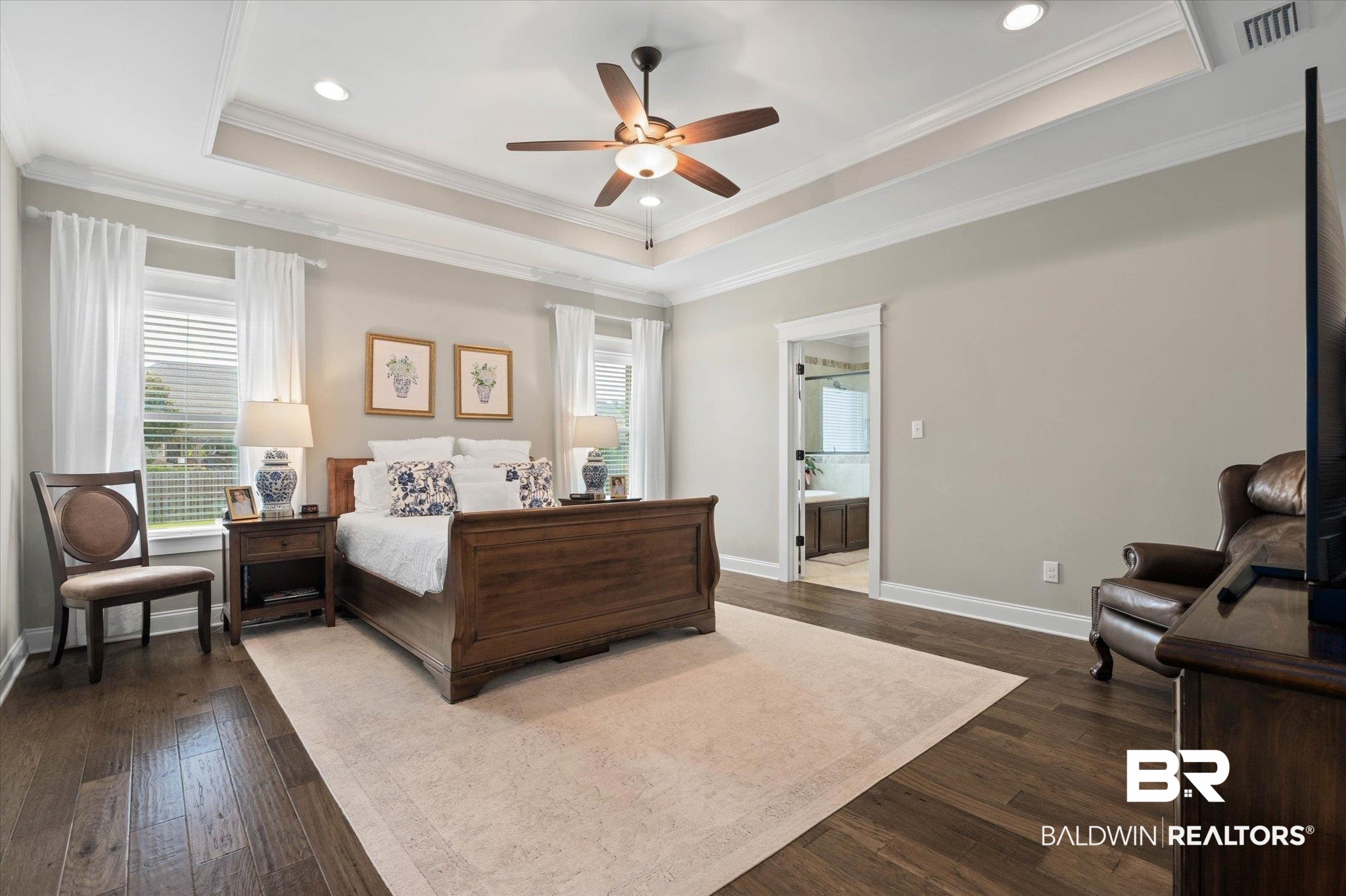 24821 Austin Road Daphne, AL 36526 - Photo 9 of 24 Bedroom with a tray ceiling, dark wood-type flooring, crown molding, ensuite bath, and ceiling fan