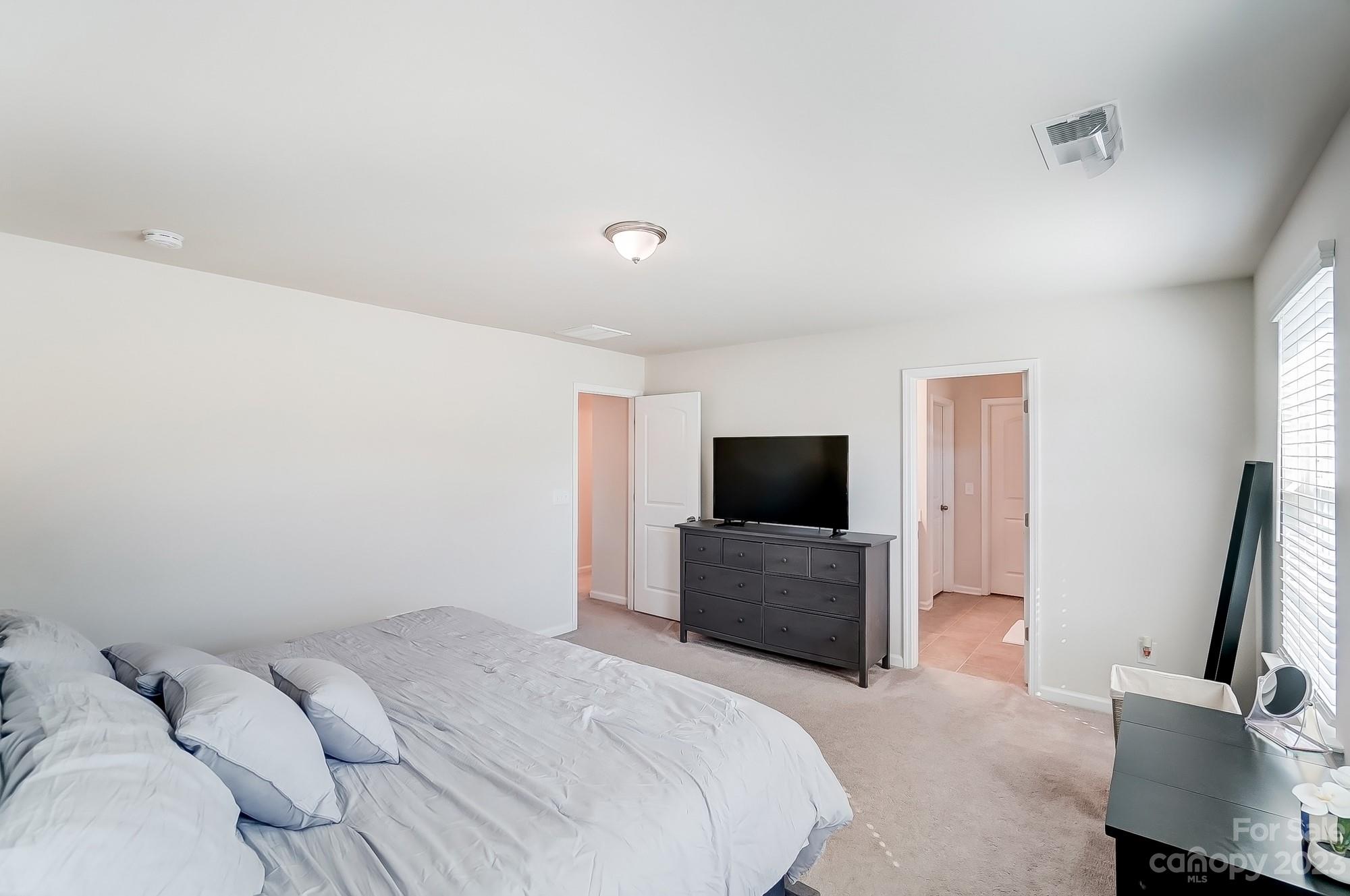 1712 Loggerhead Drive Lancaster, SC 29720 - Photo 18 of 43 a bedroom with a bed and a flat tv screen on wall