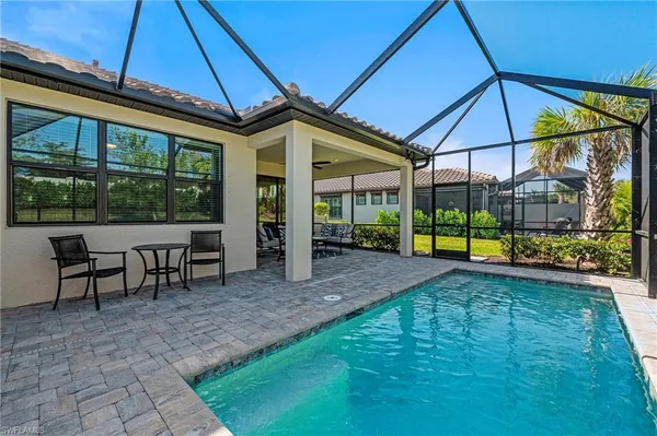 a view of a patio with table and chairs under an umbrella