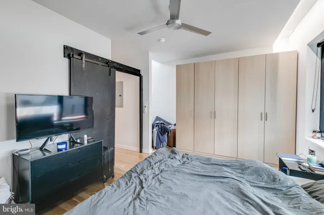 a bedroom with bed and a flat tv screen