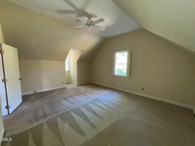 an empty room with windows and fireplace