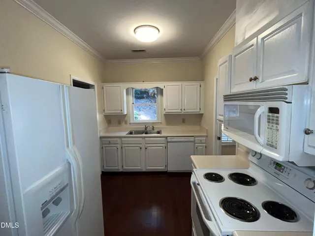 a kitchen with a sink a refrigerator and cabinets