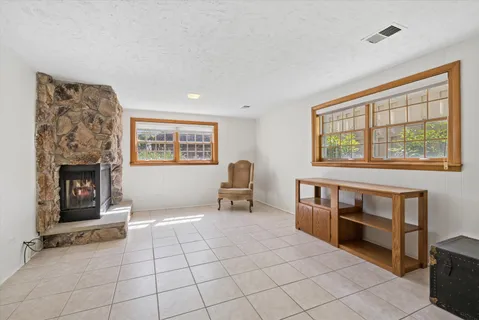 a living room with furniture a fireplace and a large window