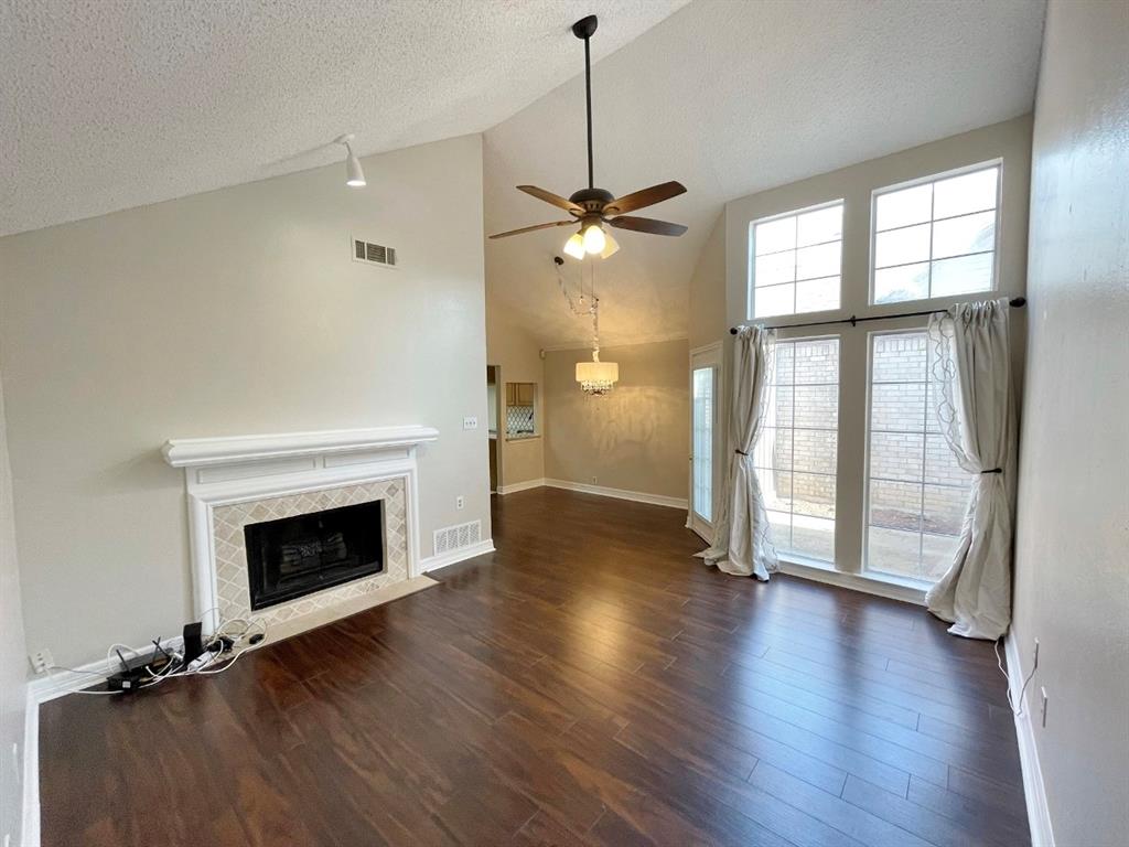 3147 Royal Gable Drive Dallas, TX 75229 - Photo 4 of 22 an empty room with wooden floor fireplace and windows