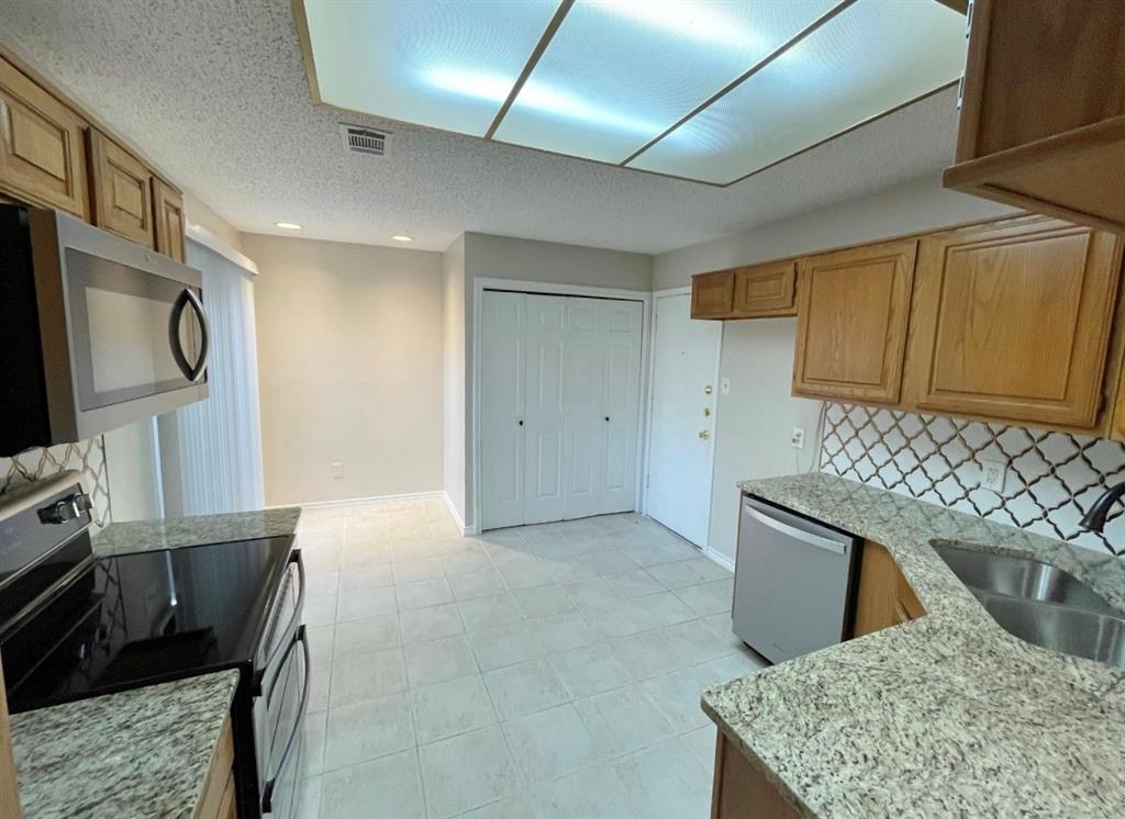 3147 Royal Gable Drive Dallas, TX 75229 - Photo 7 of 22 a kitchen with stainless steel appliances granite countertop a sink stove and refrigerator