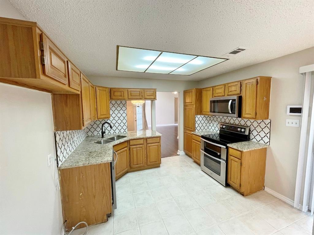 3147 Royal Gable Drive Dallas, TX 75229 - Photo 9 of 22 a kitchen with granite countertop a stove oven and sink