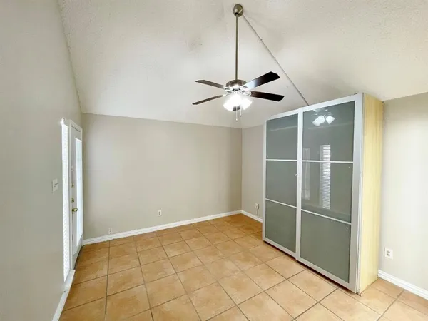 a view of a room with a ceiling fan and entryway