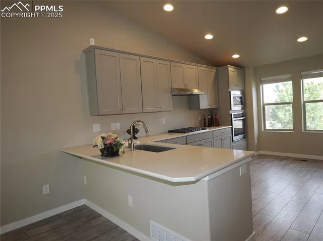 a kitchen with a sink and wooden floor