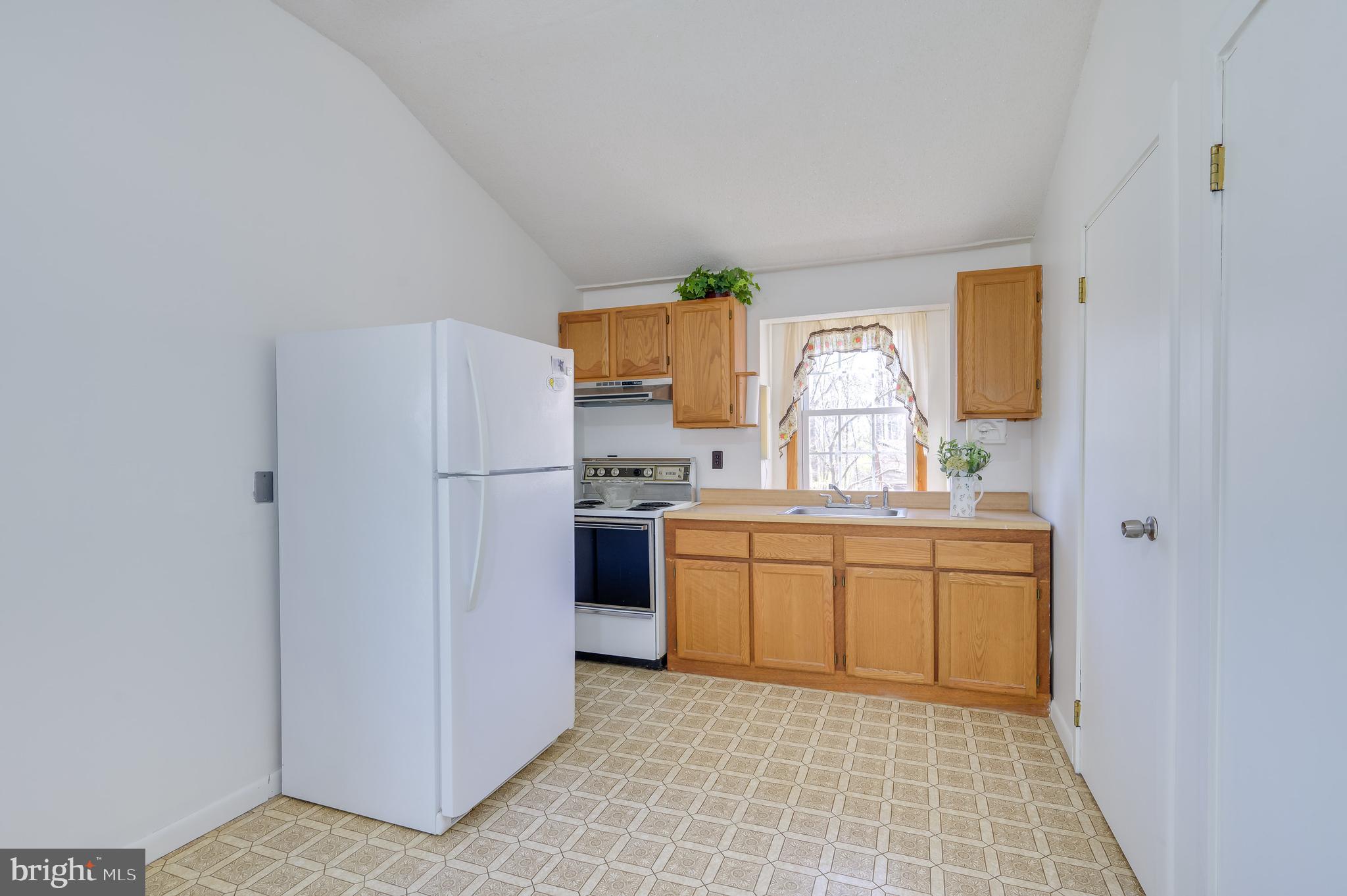 1524 Lamplight Road Bunker Hill, WV 25413 - Photo 12 of 44 a kitchen with a refrigerator a stove a sink and a window