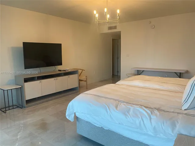 a bedroom with a bed and a flat tv screen on wall