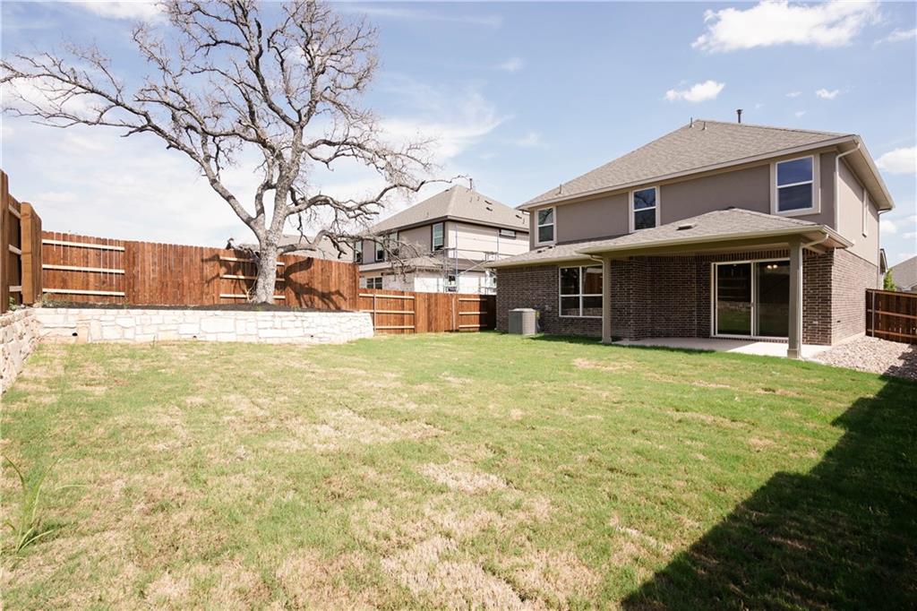 2341 Gabriels Horn Road Leander, TX 78641 - Photo 17 of 20 Back of house with a patio, a fenced backyard, brick siding, and roof with shingles