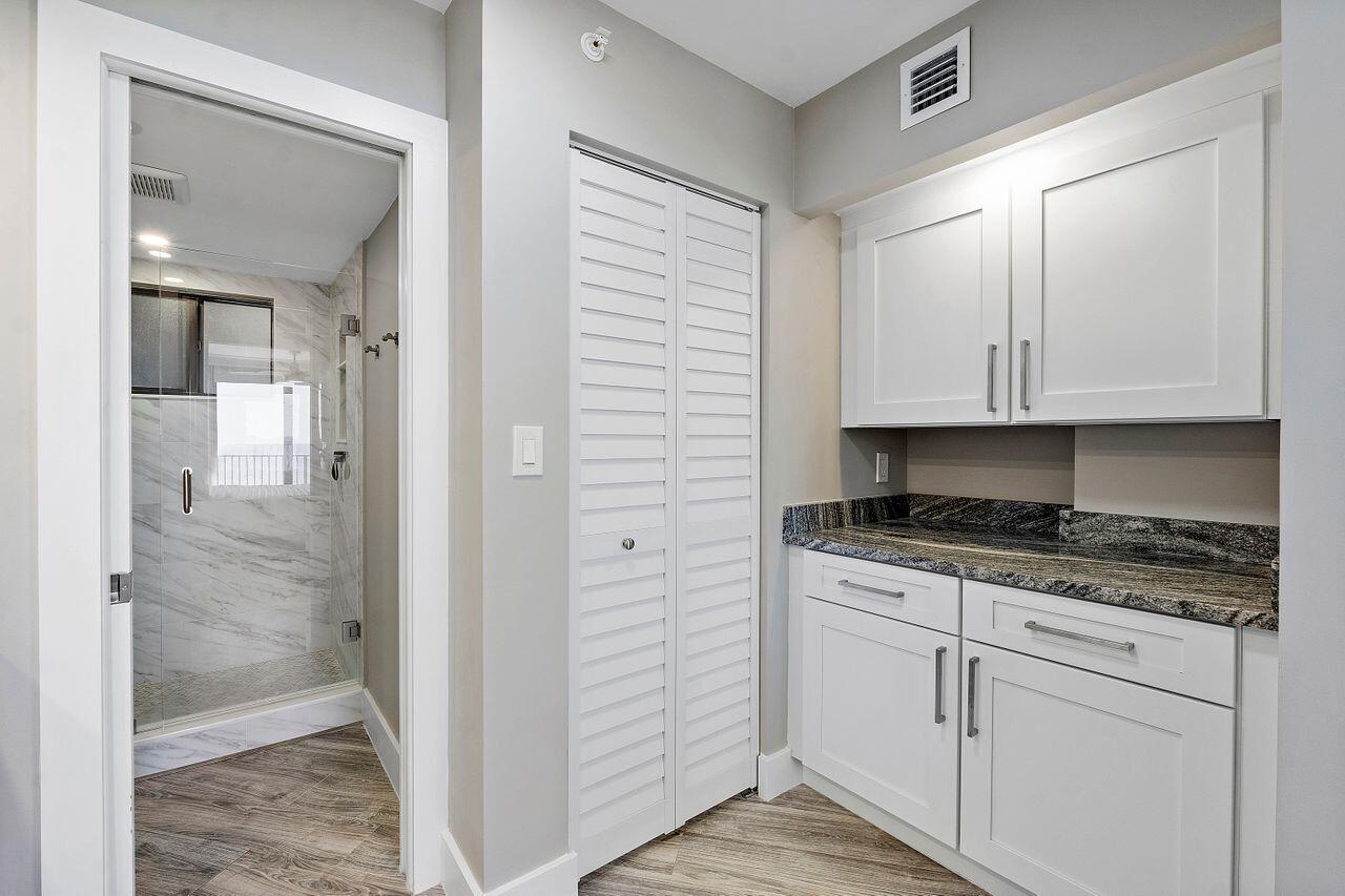 200 Ocean Trail Way, Unit 602 Jupiter, FL 33477 - Photo 22 of 50 a kitchen with granite countertop white cabinets and white appliances