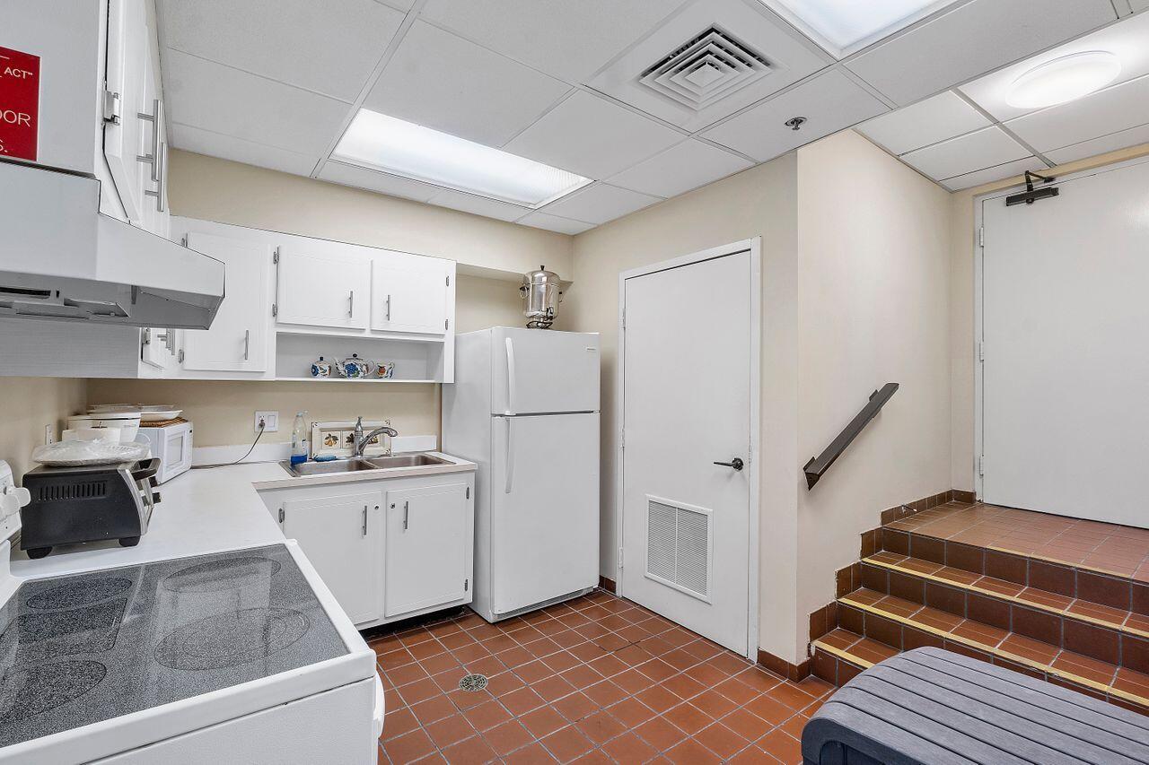 200 Ocean Trail Way, Unit 602 Jupiter, FL 33477 - Photo 44 of 50 a kitchen with white cabinets and white appliances