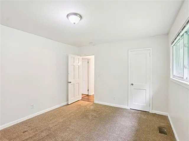 an empty room with windows and closet