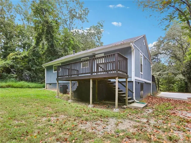 a view of a house with a yard and a large tree