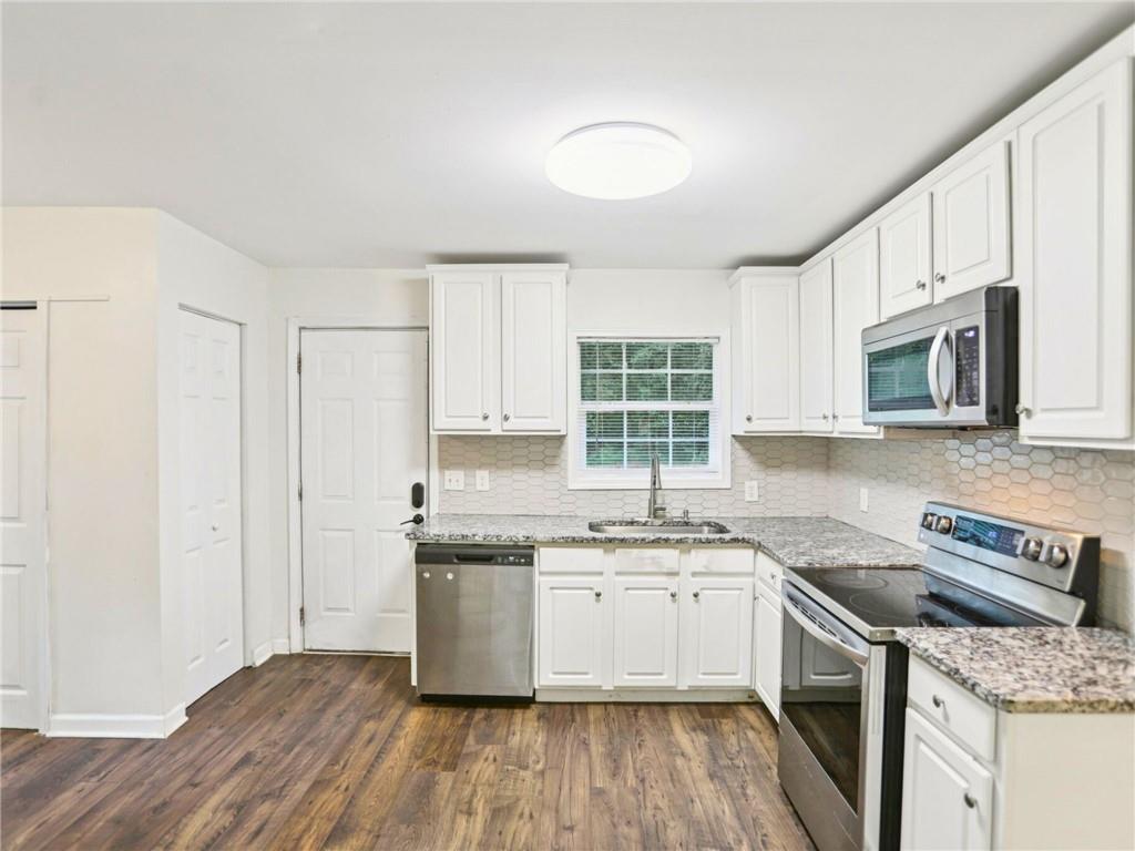 1918 West Kimberly Road Southwest Atlanta, GA 30331 - Photo 6 of 23 a kitchen with stainless steel appliances granite countertop a sink a stove a refrigerator and cabinets