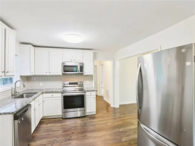 a kitchen with stainless steel appliances a stove a sink and a refrigerator