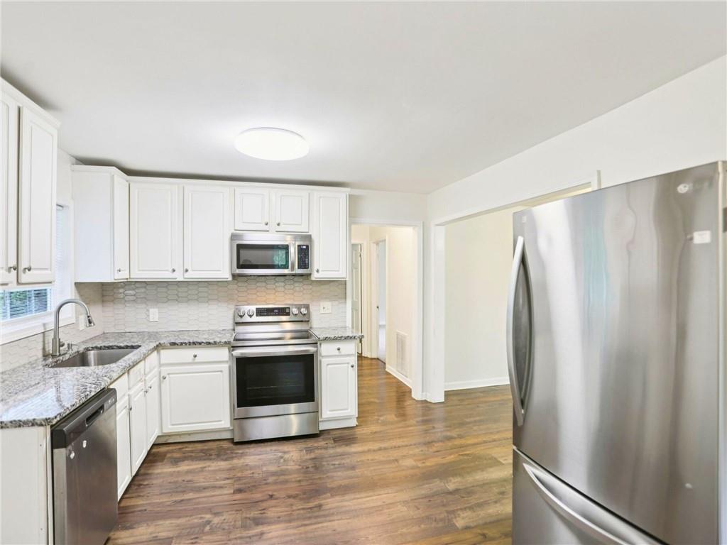 1918 West Kimberly Road Southwest Atlanta, GA 30331 - Photo 7 of 23 a kitchen with stainless steel appliances a stove a sink and a refrigerator