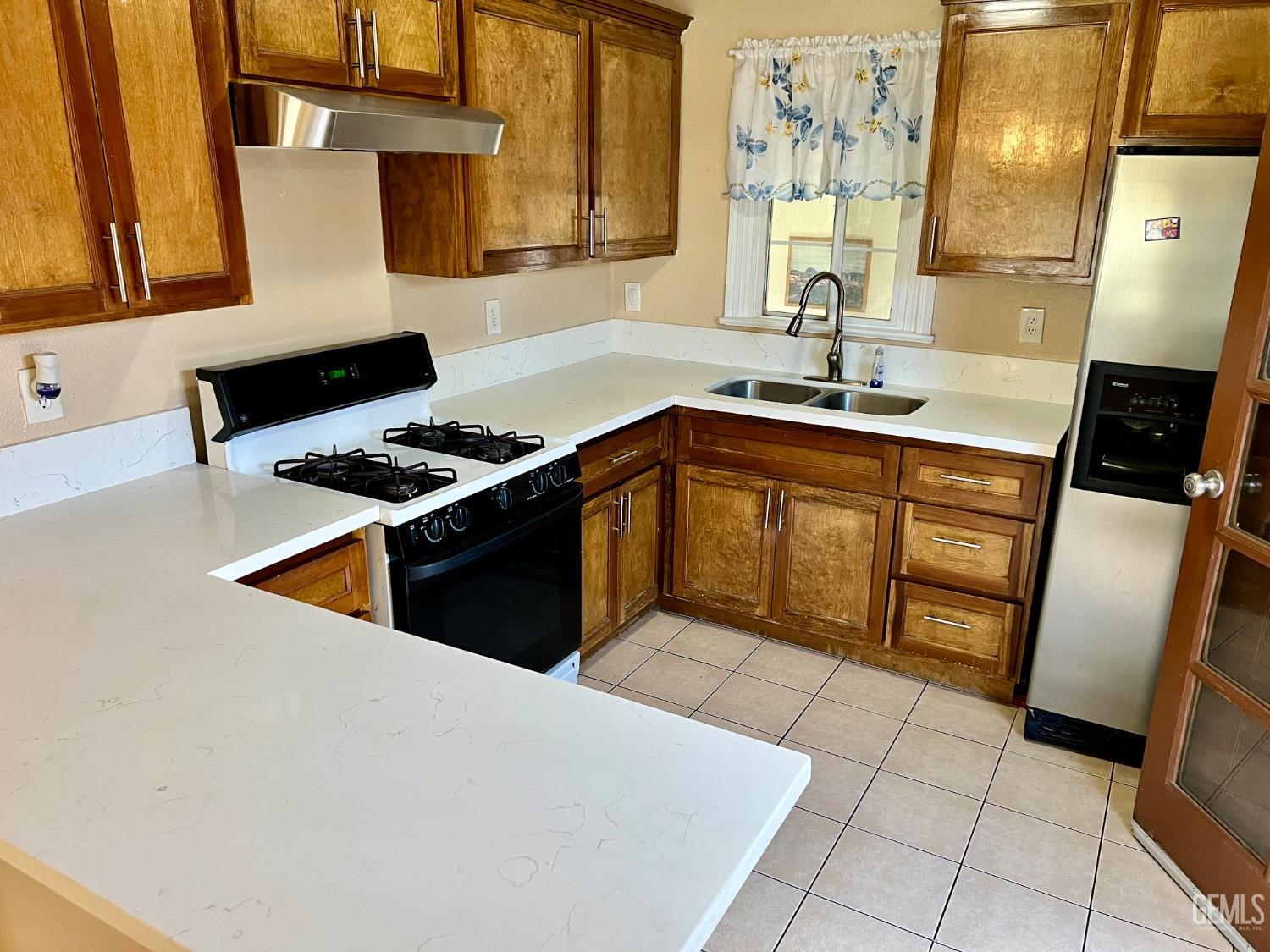 Undisclosed Address Wasco, CA 93280 - Photo 7 of 24 a kitchen with stainless steel appliances a stove a sink and a refrigerator