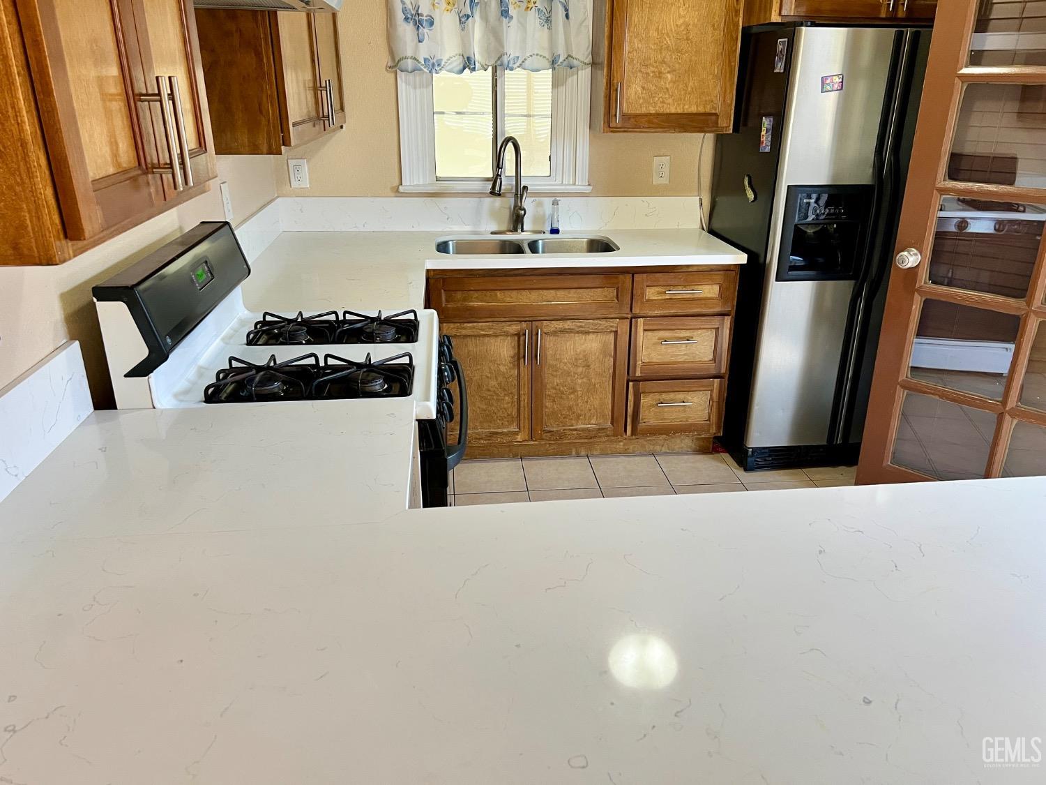 Undisclosed Address Wasco, CA 93280 - Photo 8 of 24 a kitchen with stainless steel appliances a stove a sink a refrigerator and a large window