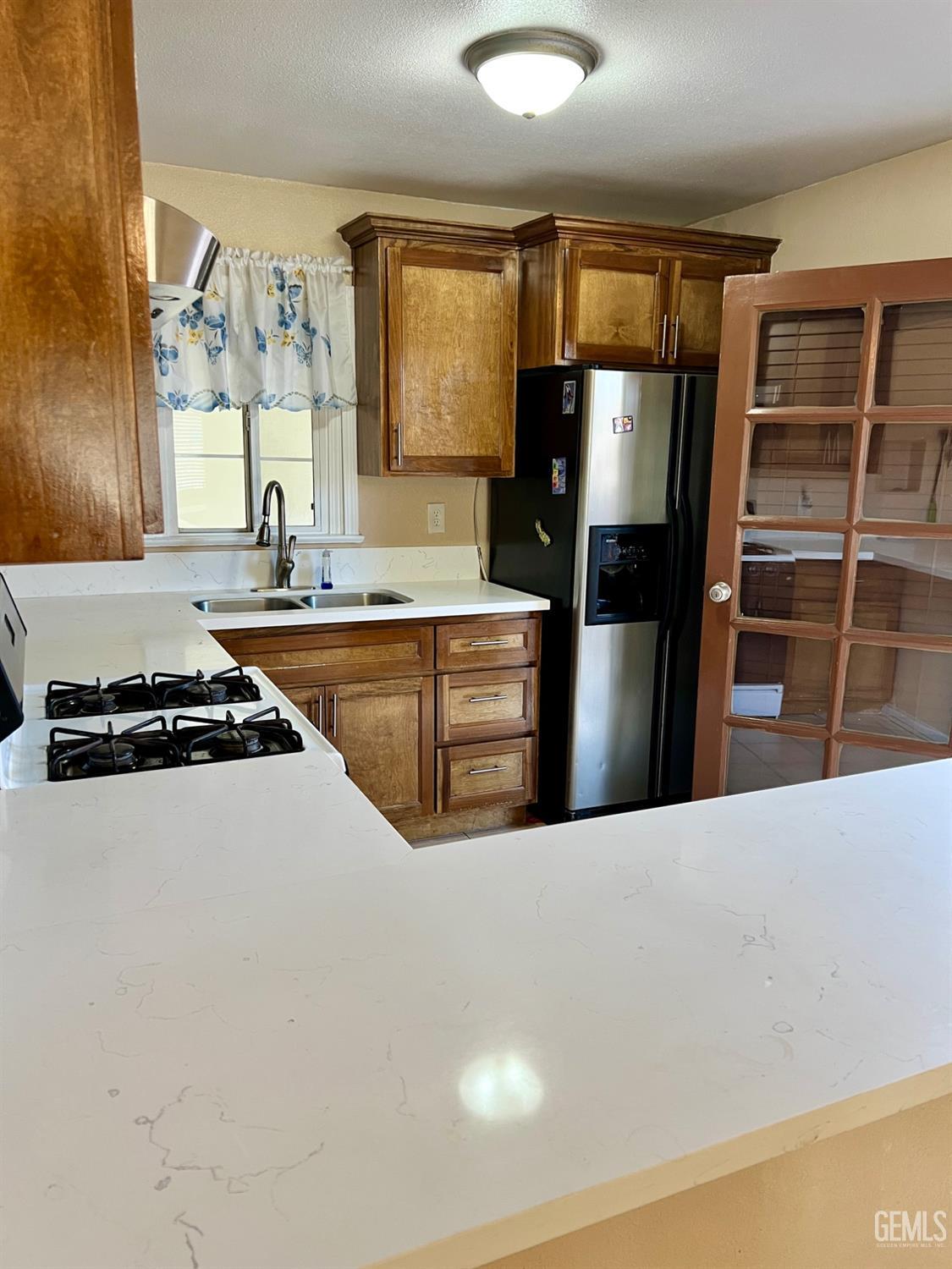 Undisclosed Address Wasco, CA 93280 - Photo 9 of 24 a kitchen with stainless steel appliances a refrigerator a stove a sink and a window