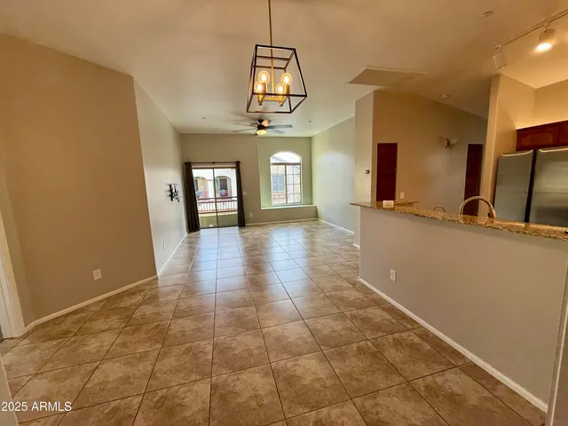 a view of a hallway with wooden floor and a chandelier