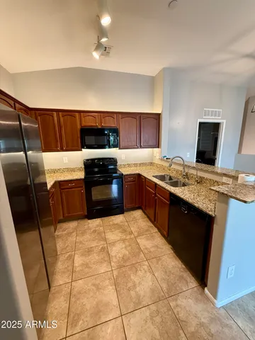 a kitchen with granite countertop a sink and a microwave