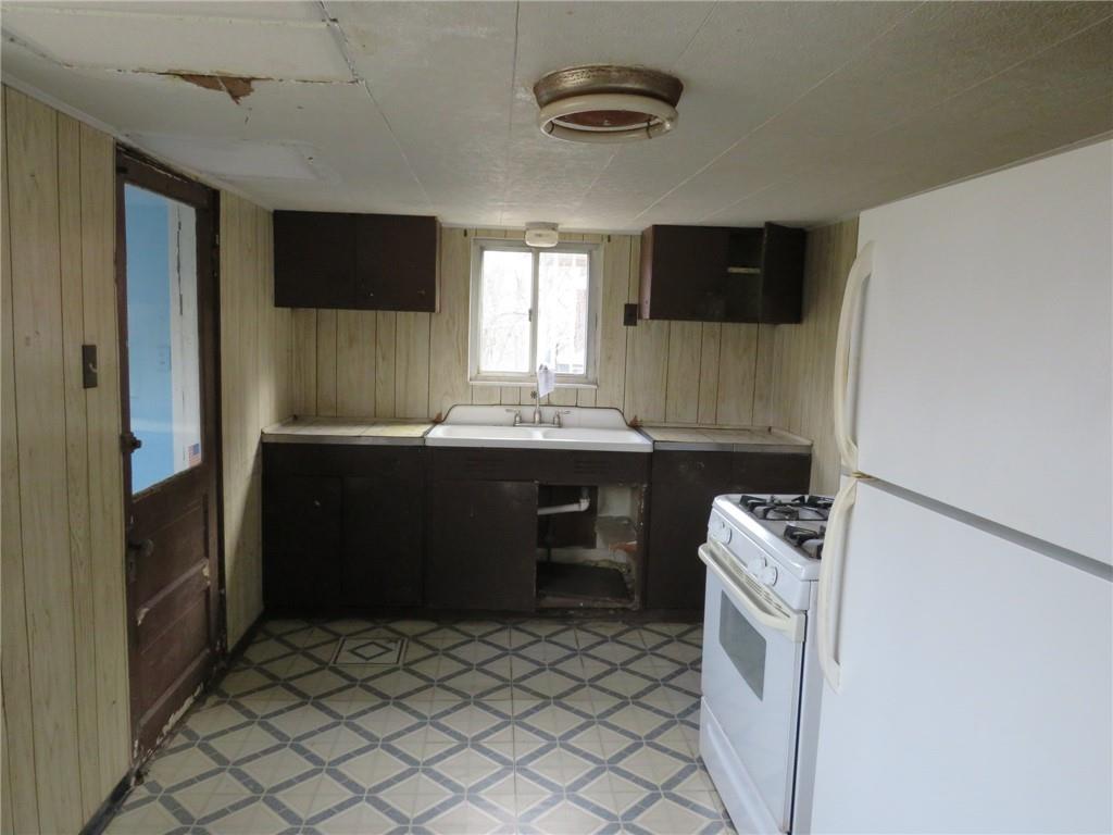 407 Linnview Avenue Pittsburgh, PA 15210 - Photo 21 of 38 a room with furniture a flat screen tv and a refrigerator