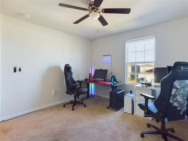 a view of a workspace with furniture and a window