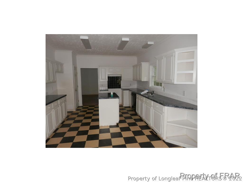 248 St Matthews Church Road Raeford, NC 28376 - Photo 14 of 14 a kitchen with a sink and white cabinets