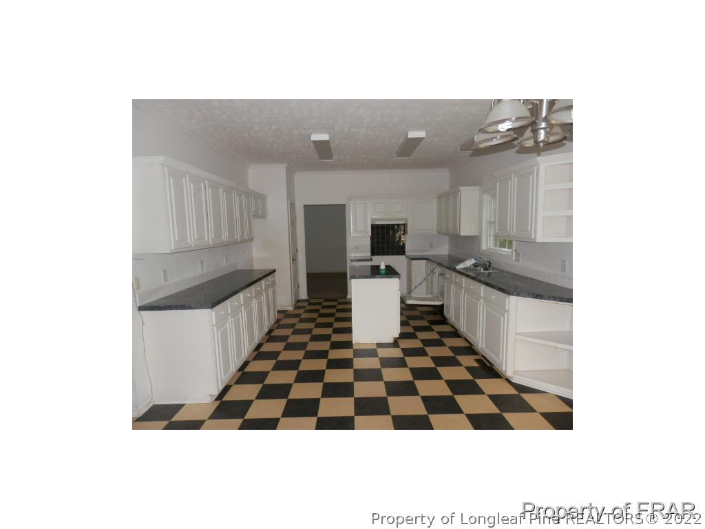 248 St Matthews Church Road Raeford, NC 28376 - Photo 6 of 14 a kitchen with a sink a stove and cabinets