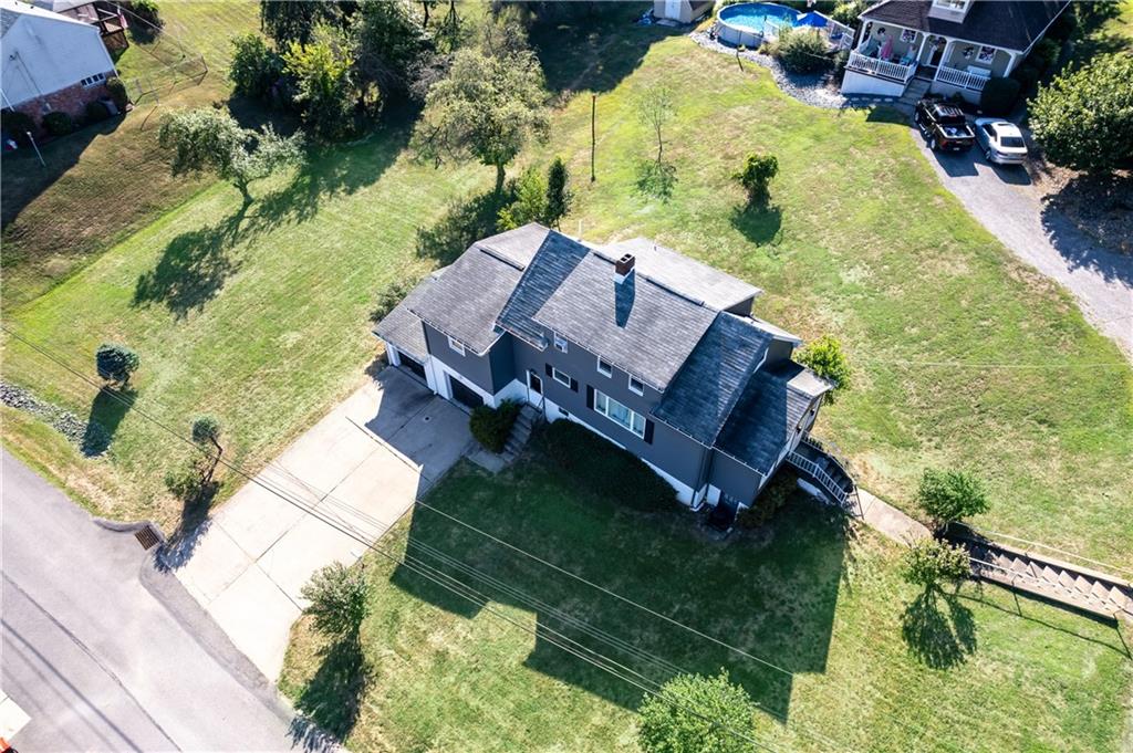 an aerial view of a house with a yard basket ball court and outdoor seating