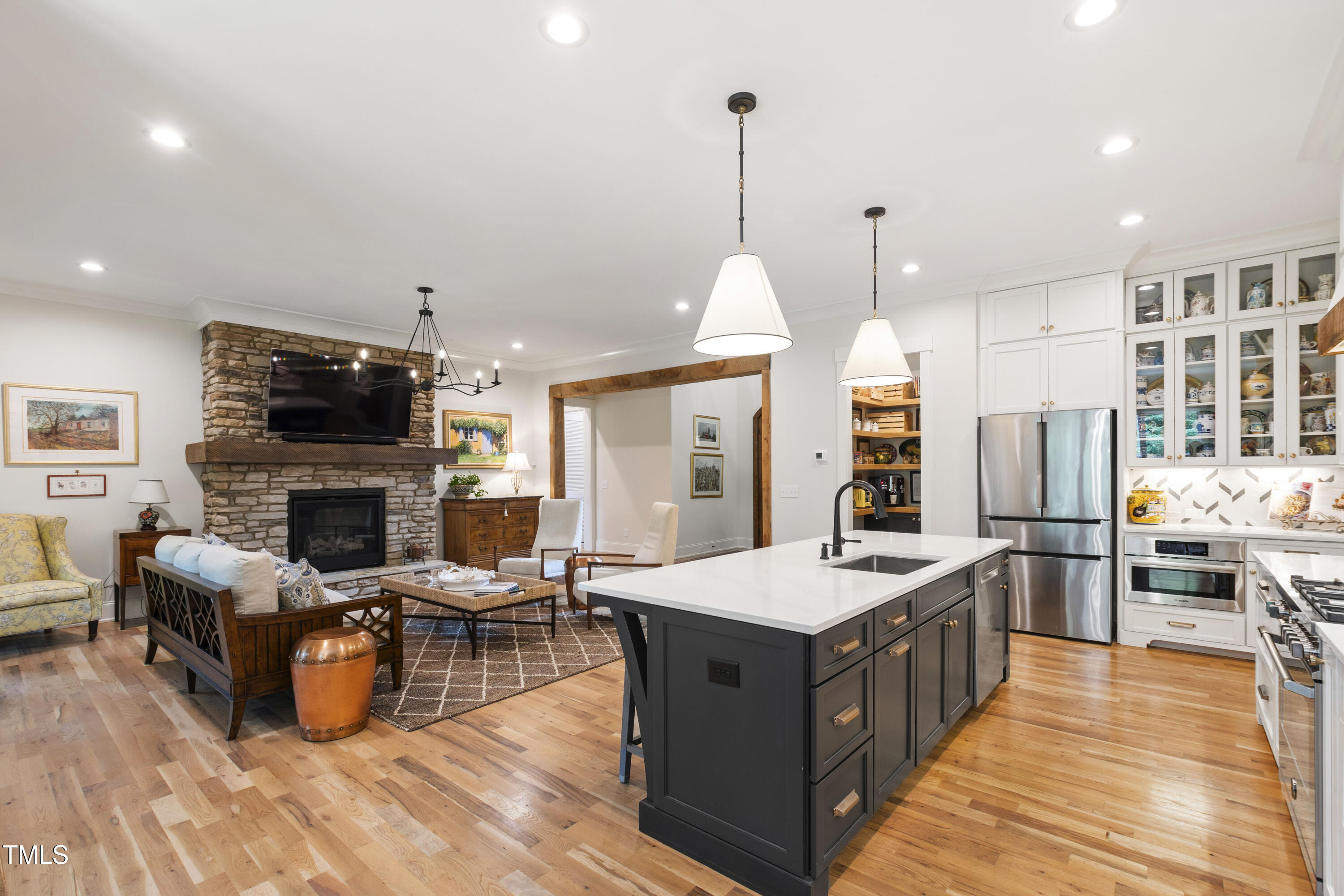 541 Sunset Grove Drive Pittsboro, NC 27312 - Photo 19 of 75 a large kitchen with stainless steel appliances kitchen island granite countertop a large stove a sink dishwasher and a fireplace with wooden floor