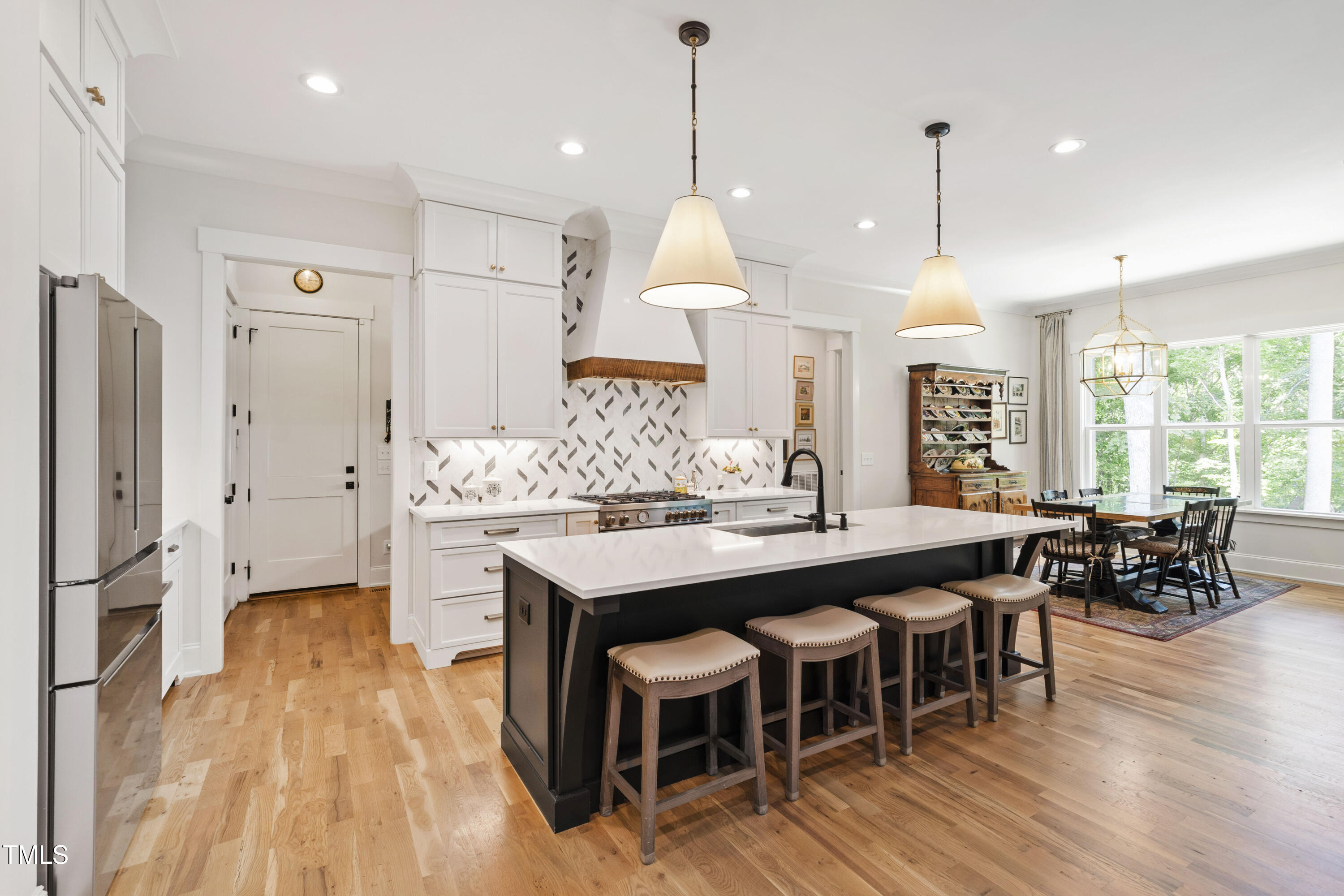 541 Sunset Grove Drive Pittsboro, NC 27312 - Photo 4 of 75 a kitchen with stainless steel appliances granite countertop a table chairs stove a refrigerator a kitchen island a sink and a wooden floor