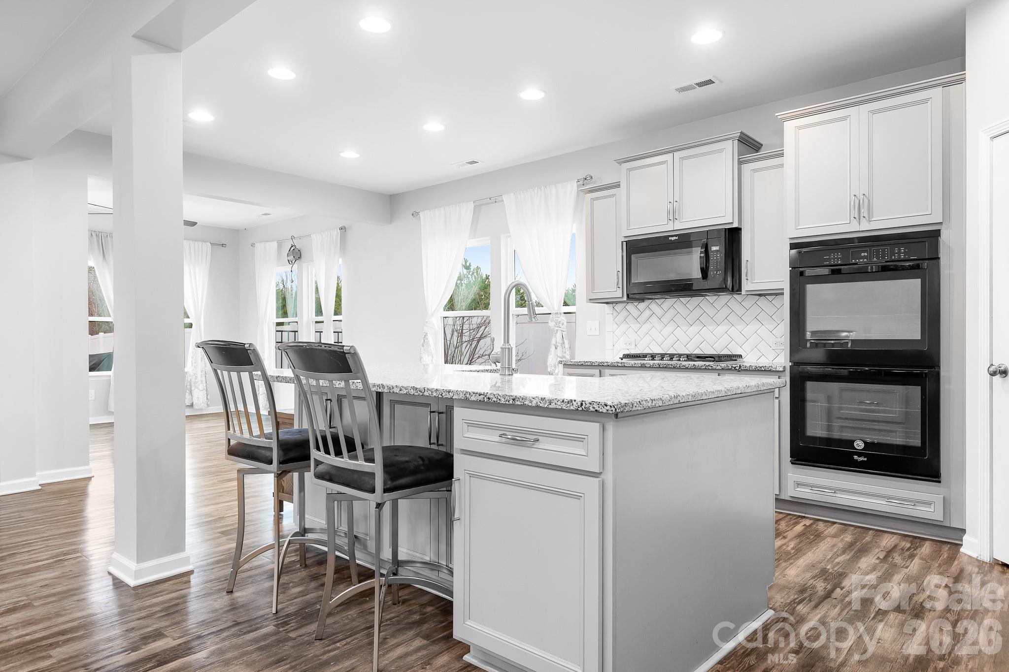 6308 Durango Way Denver, NC 28037 - Photo 3 of 45 a kitchen with kitchen island granite countertop a stove and a wooden floor