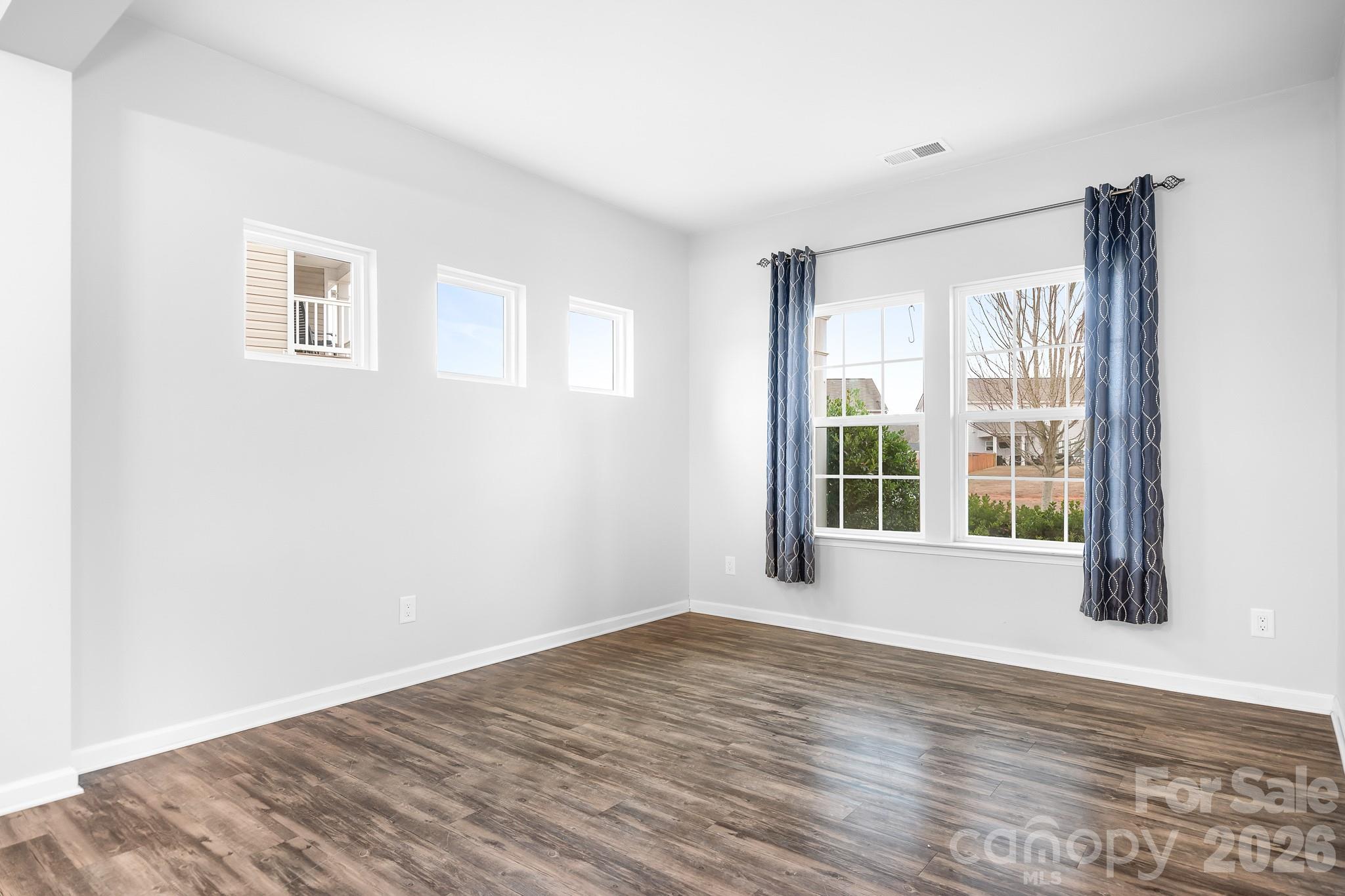 6308 Durango Way Denver, NC 28037 - Photo 9 of 45 a view of an empty room with wooden floor and a window