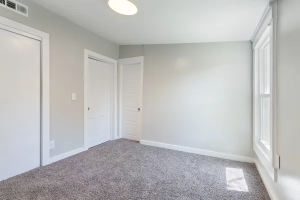 an empty room with windows and closet