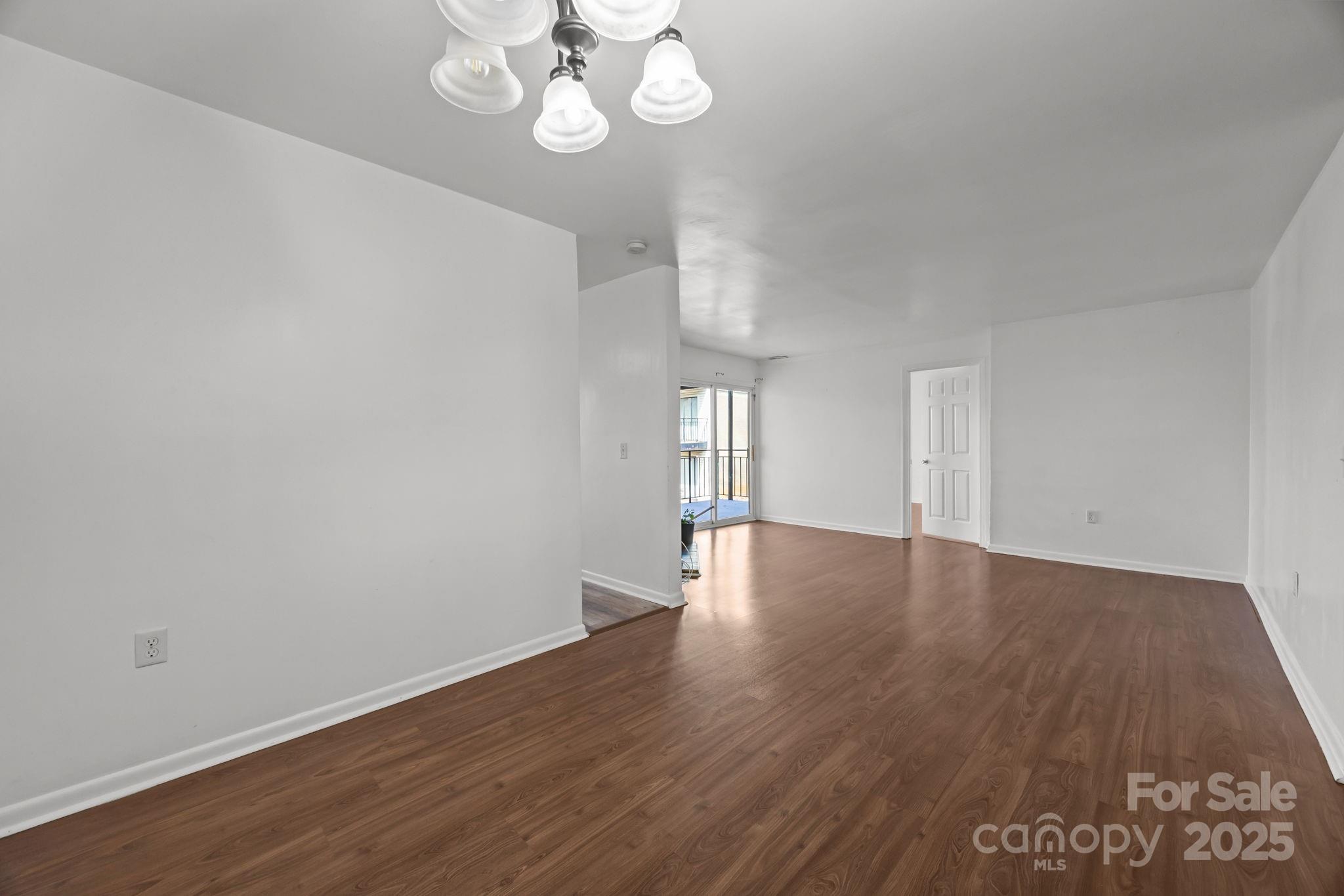 4902 Spring Lake Drive, Unit D Charlotte, NC 28212 - Photo 12 of 30 a view of an empty room with wooden floor and a window