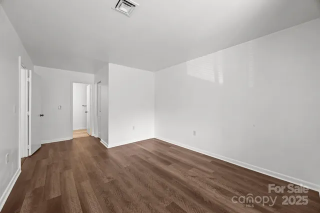 a view of an empty room with wooden floor