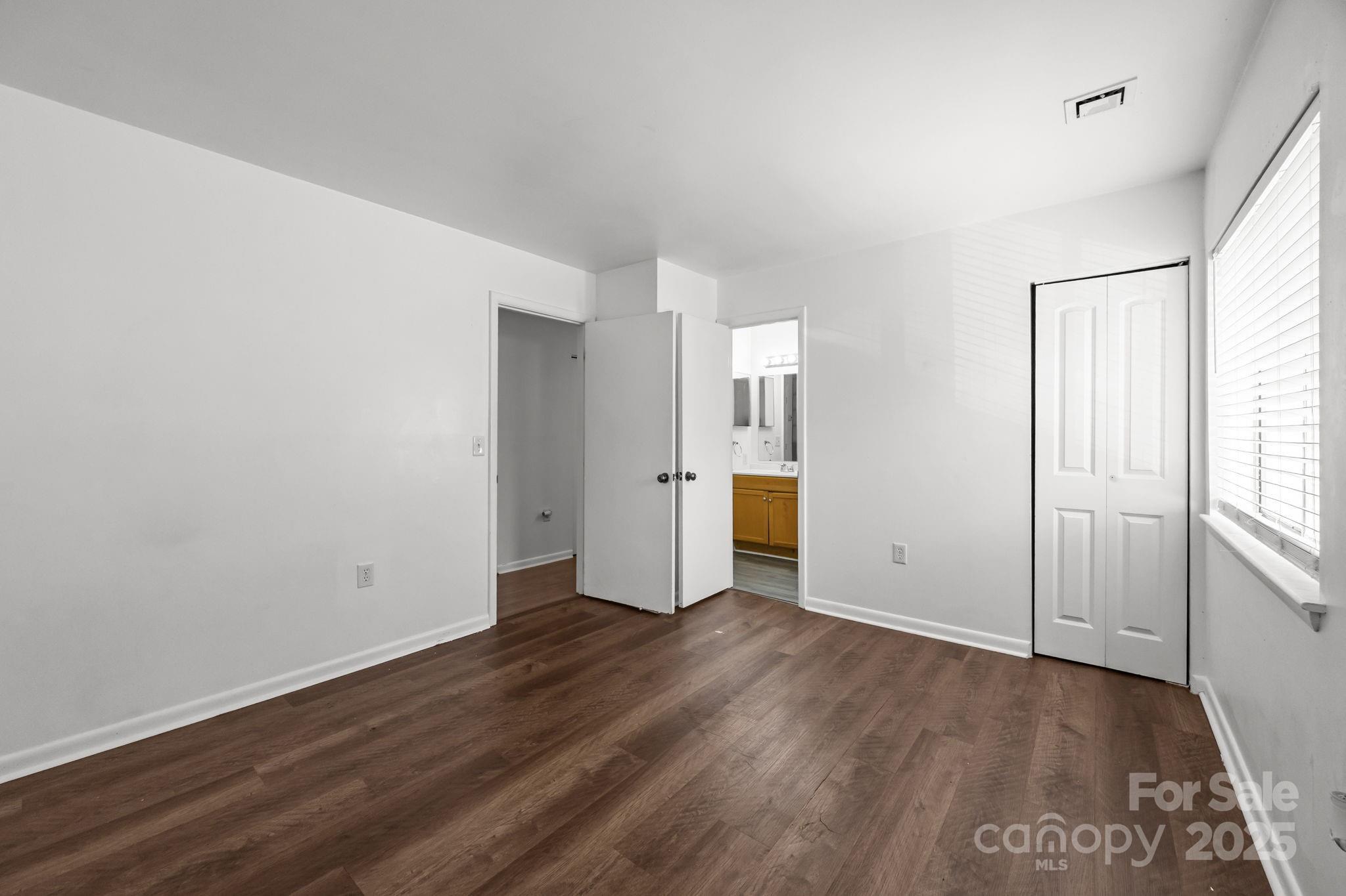 4902 Spring Lake Drive, Unit D Charlotte, NC 28212 - Photo 17 of 30 an empty room with wooden floor and windows