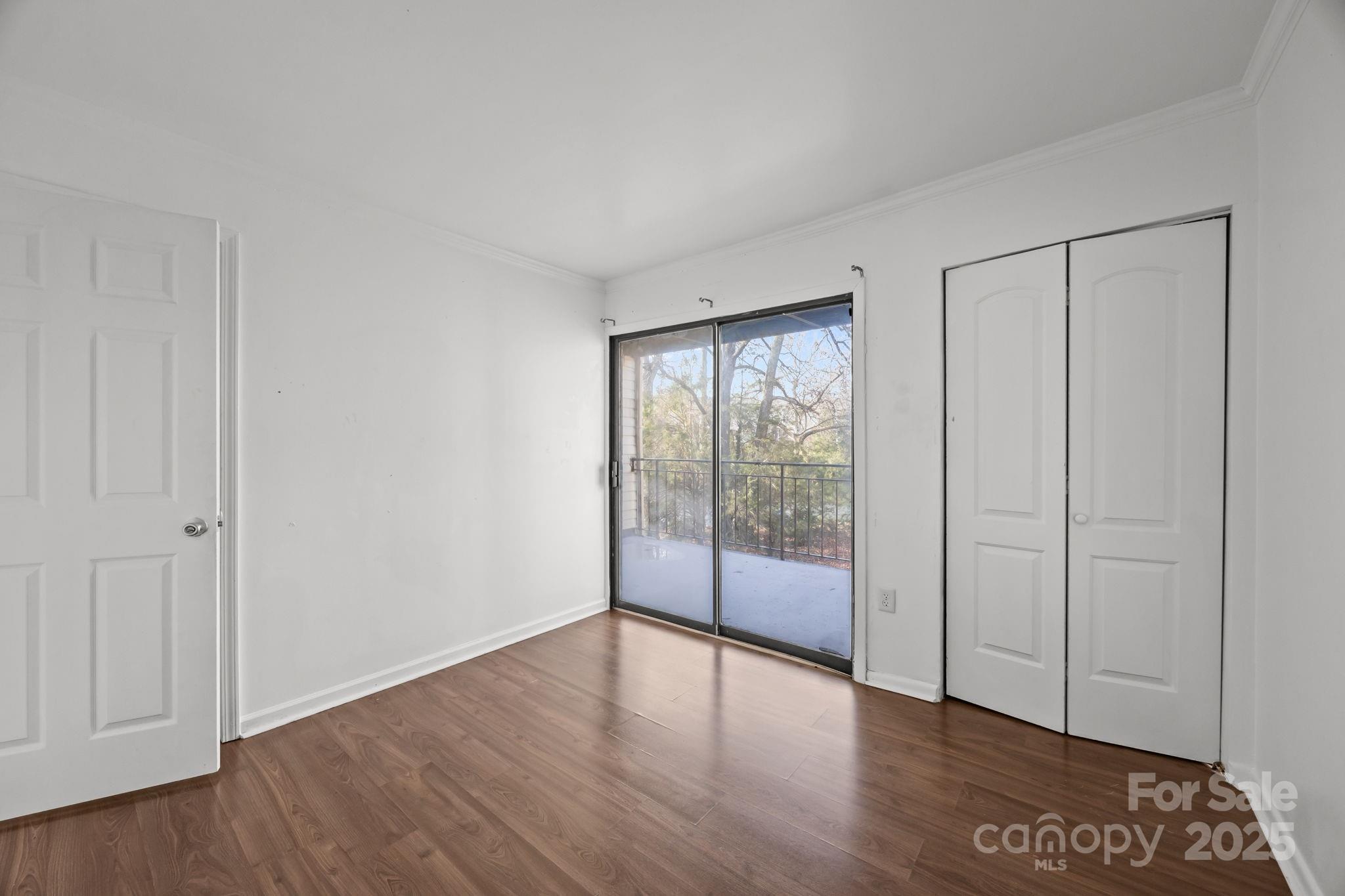 4902 Spring Lake Drive, Unit D Charlotte, NC 28212 - Photo 22 of 30 an empty room with wooden floor and windows