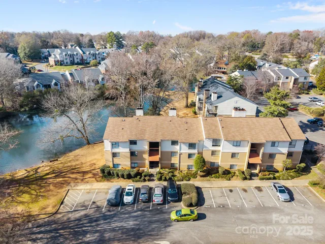 an aerial view of residential houses with outdoor space and lake view