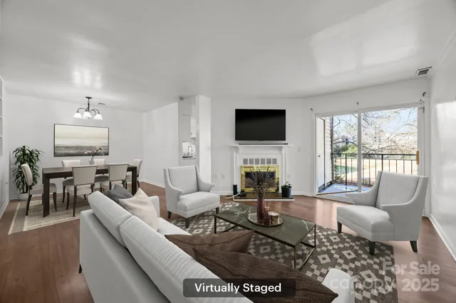 a living room with furniture a fireplace a flat screen tv and a large window