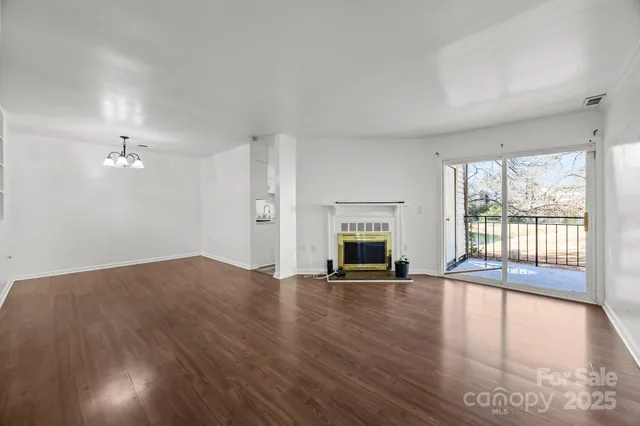 a view of empty room with wooden floor and fireplace