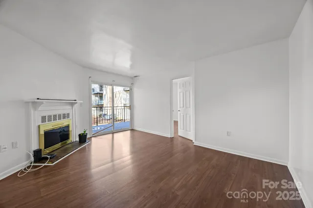 an empty room with floor to ceiling window and fireplace