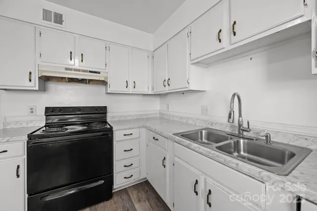 a kitchen with white cabinets and appliances