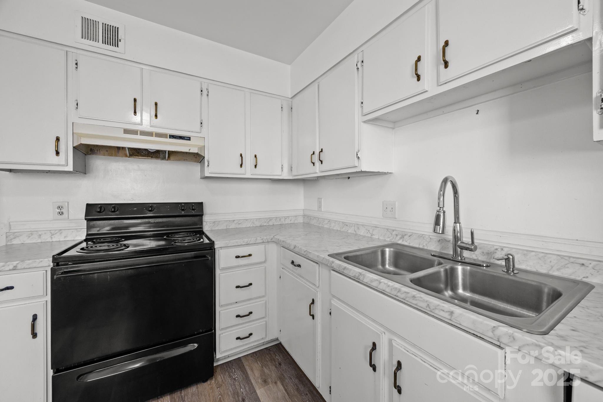 4902 Spring Lake Drive, Unit D Charlotte, NC 28212 - Photo 9 of 30 a kitchen with white cabinets and appliances