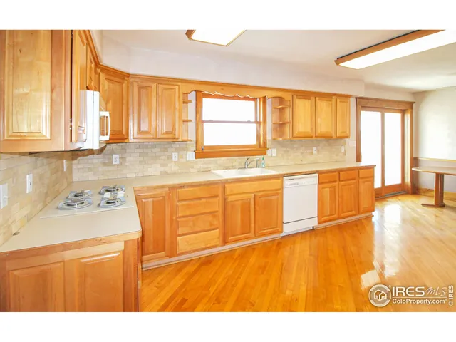 a large kitchen with stainless steel appliances granite countertop a granite counter tops and a view of living room