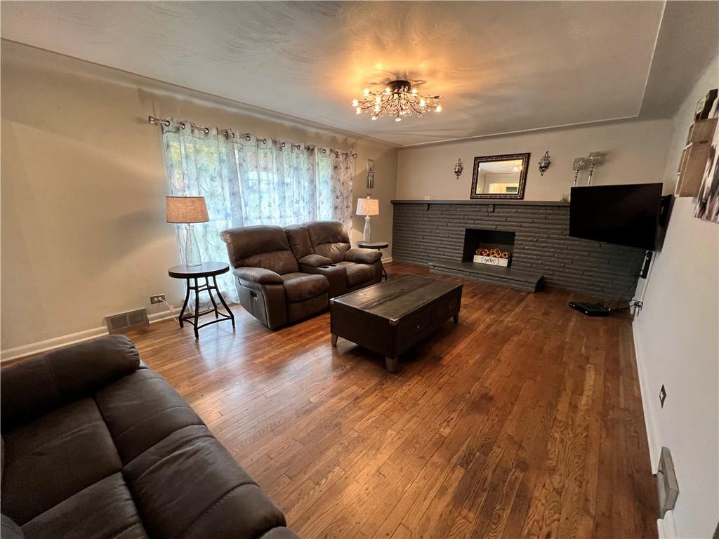 100 Randy Drive Butler, PA 16002 - Photo 3 of 25 a living room with furniture a fireplace and a chandelier