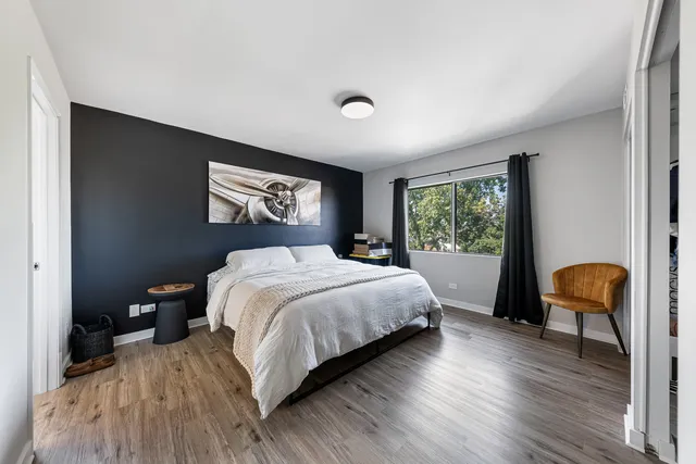 a spacious bedroom with a bed and a chair